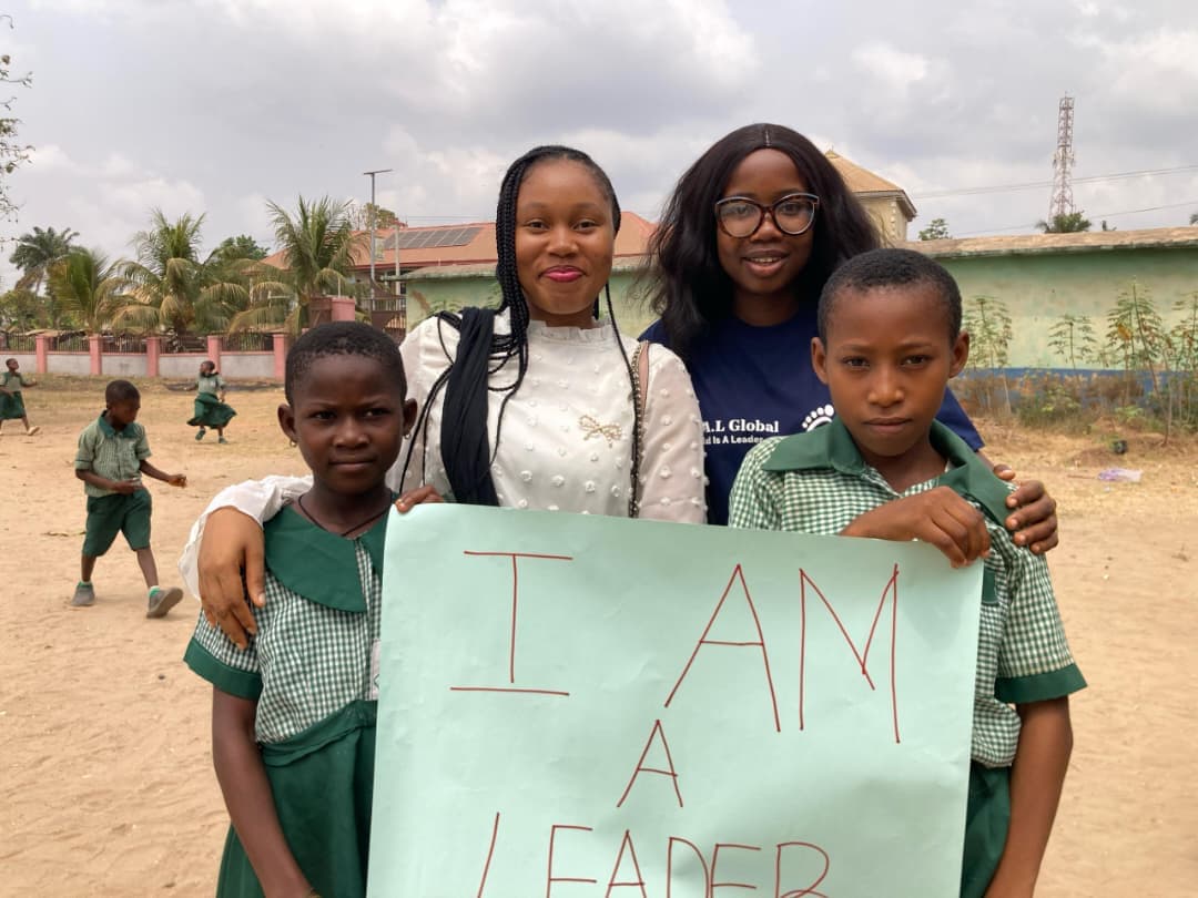 Emmanuella with children holding cardboard paper